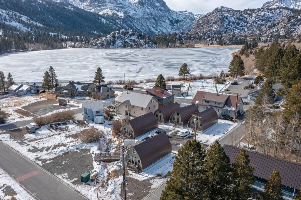 Aerial view of the five detached cabins at The Acorns Village with June Lake and the Eastern Sierra beyond