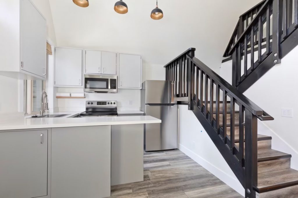 Open-concept great room, kitchen and staircase inside a two-bedroom cabin at The Acorns Village, June Lake CA